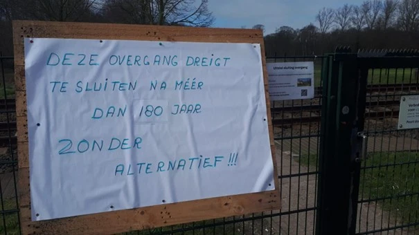 Protestbord bij de overgang: Deze overgang dreigt te sluiten na meer dan 180 jaar zonder alternatief